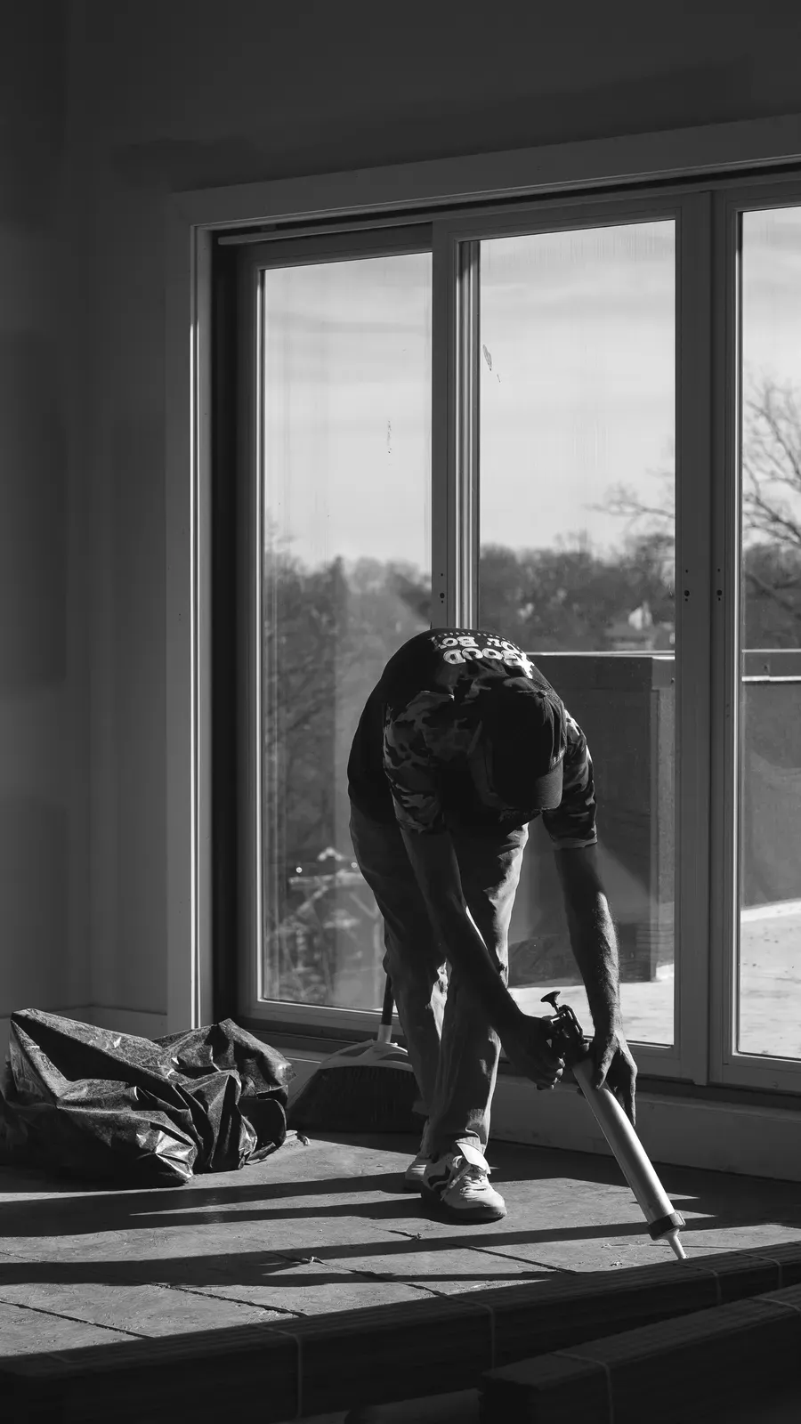 Good Ol’ Boy Hardwood Floors crew member working along a window wall