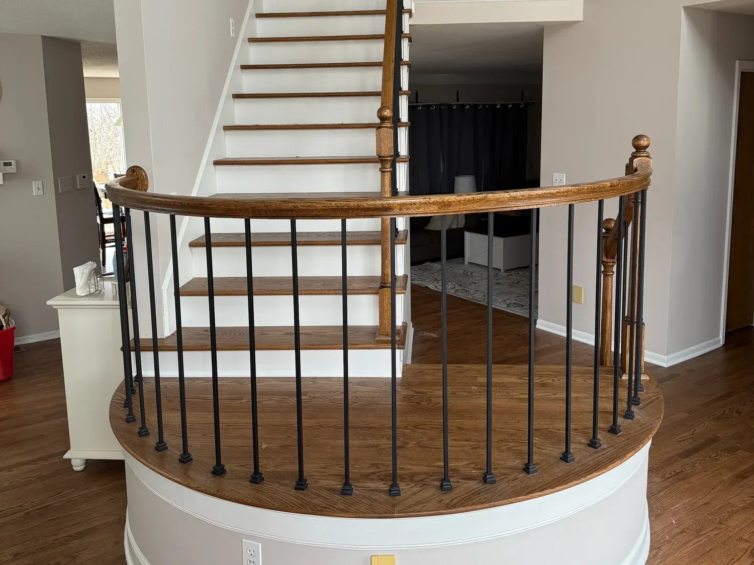 Restored curved staircase with refinished oak floor and new iron balusters by Good Ol' Boy